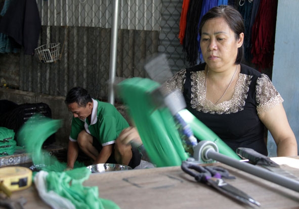 Bà Nguyễn Thị Thanh Thúy quay sợi vải màn làm đầu cây lau nhà.