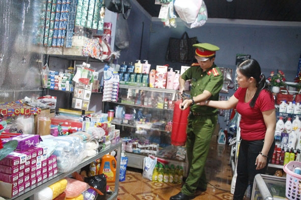 Công an huyện Krông Ana hướng dẫn tiểu thương cách sử dụng bình chữa cháy.