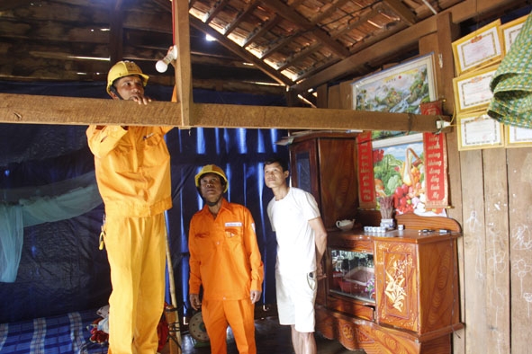Công nhân Công ty Điện lực Đắk Lắk lắp bóng điện cho người dân buôn Xê Đăng.  