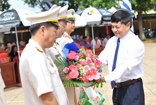 Đồng chí Phạm Minh Tấn, Phó Bí thư Thường trực Tỉnh ủy tặng hoa chúc mừng, động viên những cán bộ, chiến sĩ được điều động đảm nhiệm  các chức danh công an xã.  Ảnh: V.Thành