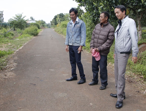 Ông Y Gôl Mlô, Bí thư Chi bộ buôn Kmrơng Prông B (bìa phải) trên con đường do nhân dân đóng góp để làm. 