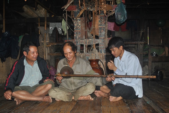 Trong ngôi nhà sàn làm từ lồ ô, già làng Hồ Văn Chính (giữa) hát bài đối đáp  có hình tượng cây lồ ô.   