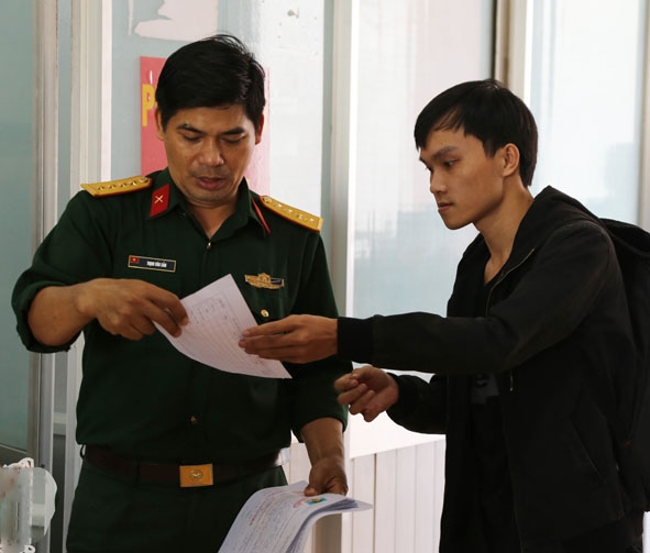 Cán bộ Ban CHQS TP. Buôn Ma Thuột kiểm tra lệnh gọi khám tuyển của thanh niên.