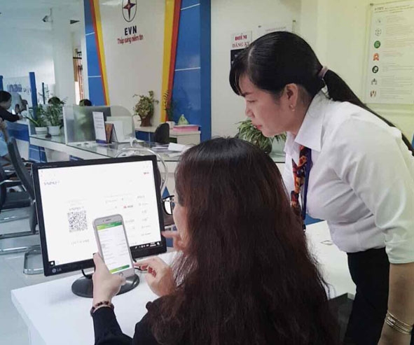 Khách hàng thanh toán tiền điện không dùng tiền mặt với điện thoại thông minh. 