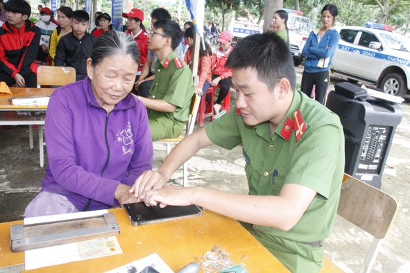 Chiến sĩ Công an huyện Krông Ana lăn dấu vân tay làm CMND cho người dân tại buôn Krông, xã Dur Kmăl. 