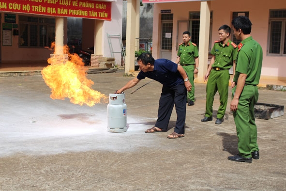 Cán bộ Đội PCCC và CNCH - Công an TP. Buôn Ma Thuột hướng dẫn tiểu thương thực hành dập tắt đám cháy.