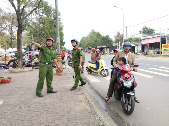 Công an thị trấn M'Đrắk hướng dẫn phụ huynh đón trẻ trước cổng Trường Mầm non Thị trấn  đậu xe đúng nơi quy định. 