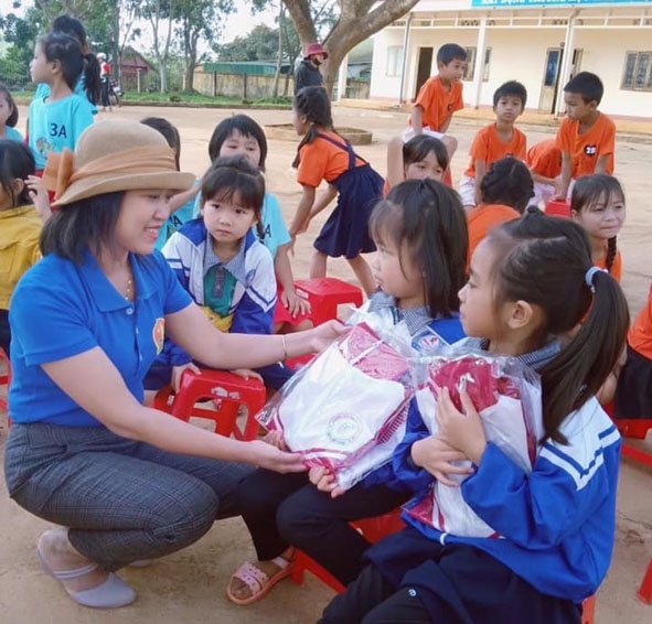 Đại diện Hội đồng Đội TP. Buôn Ma Thuột tặng áo ấm cho học sinh  tại xã Cư Né, huyện Krông Búk. 