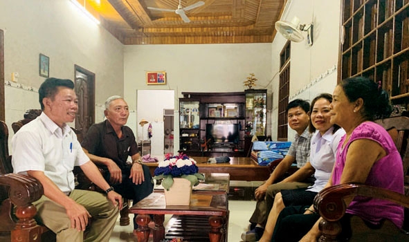 Chủ tịch UBND xã Ea Rốk Đinh Xuân Đồng (bìa trái) tuyên truyền cho người dân  về xây dựng nông thôn mới.