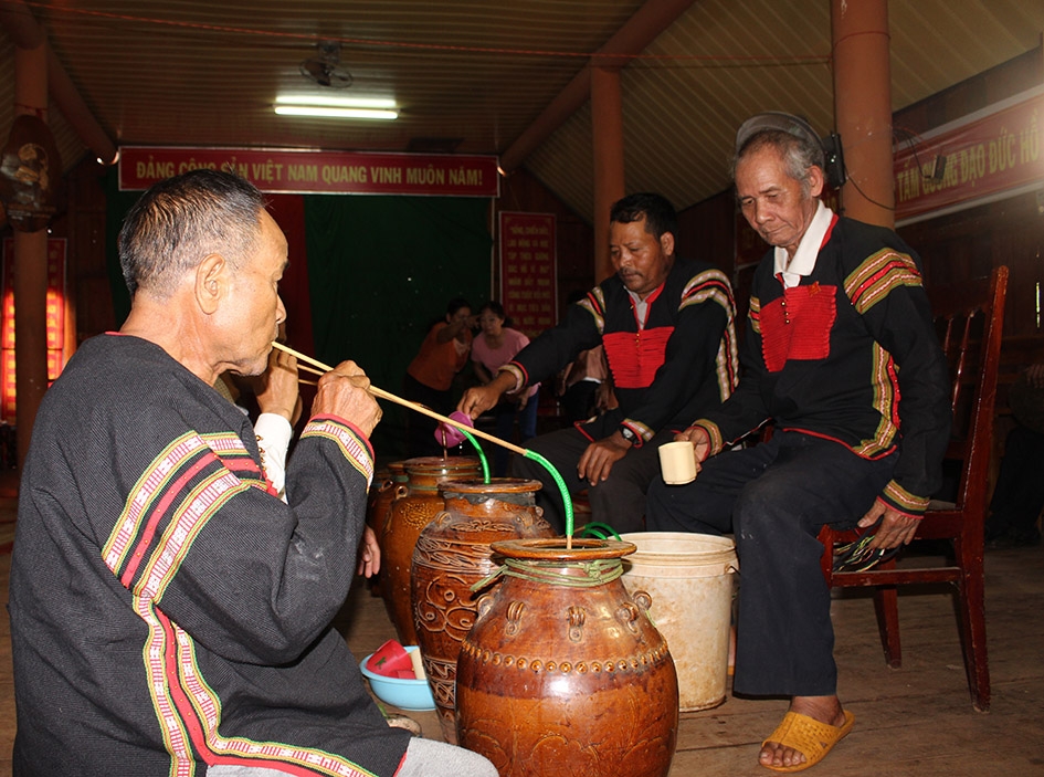 Người dân buôn Kram thưởng thức rượu cần sau lễ cúng. 