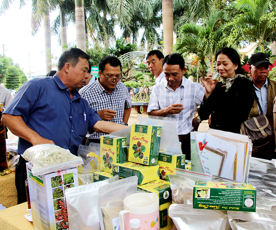 Ông Phan Đình Xuân (bìa trái) giới thiệu sản phẩm của hợp tác xã tại sự kiện xúc tiến thương mại. 