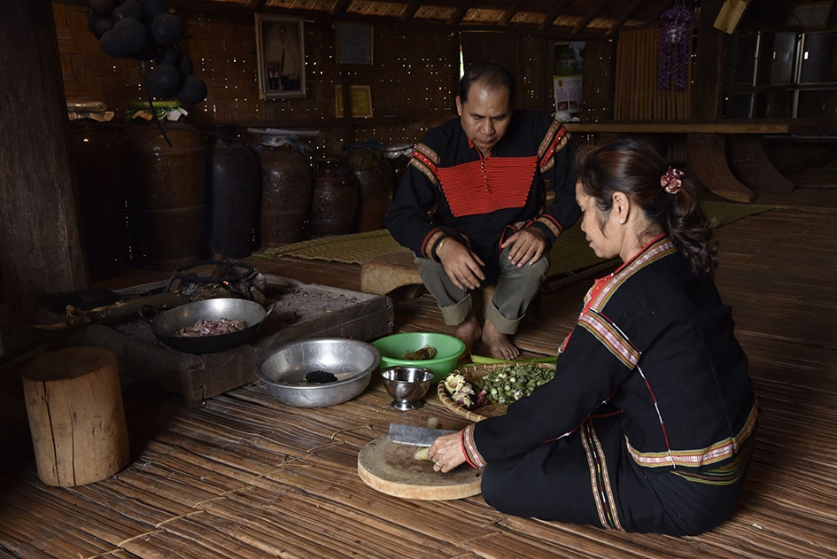 Nghệ nhân Y Thim đang sơ chế các loại rau để nấu món vếch. 