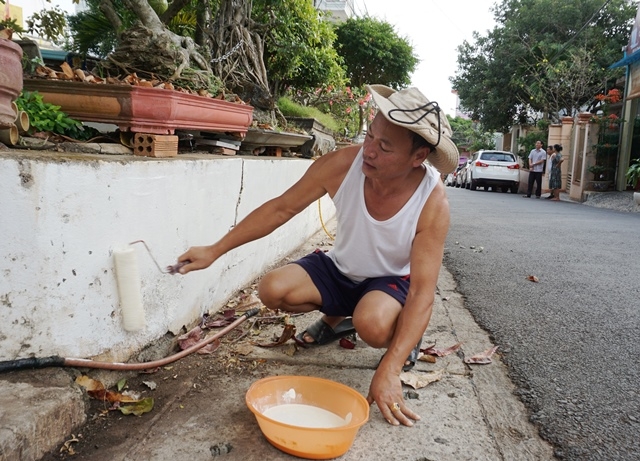 Người dân ở các tuyến đường trong thành phố sơn lại tường rào để đón Tết.