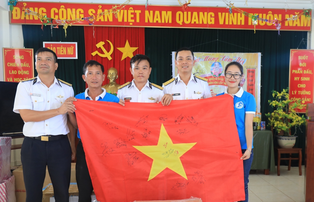 Đại diện Câu lạc bộ Tuổi trẻ vì biển đảo quê hương tặng cán bộ, chiến sĩ Đảo Len Đao lá cờ Tổ quốc có chữ ký của các cầu thủ đội tuyển U23 Việt Nam vô địch SEA GAME 30.