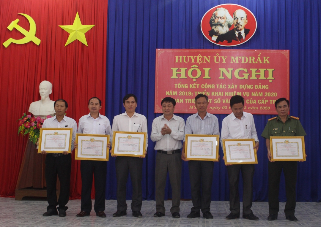 Bí thư Huyện ủy MĐrắk Hồ Duy Thành (đứng giữa) khen thưởng các TCCSĐ hoàn thành xuất sắc nhiệm vụ năm 2019.
