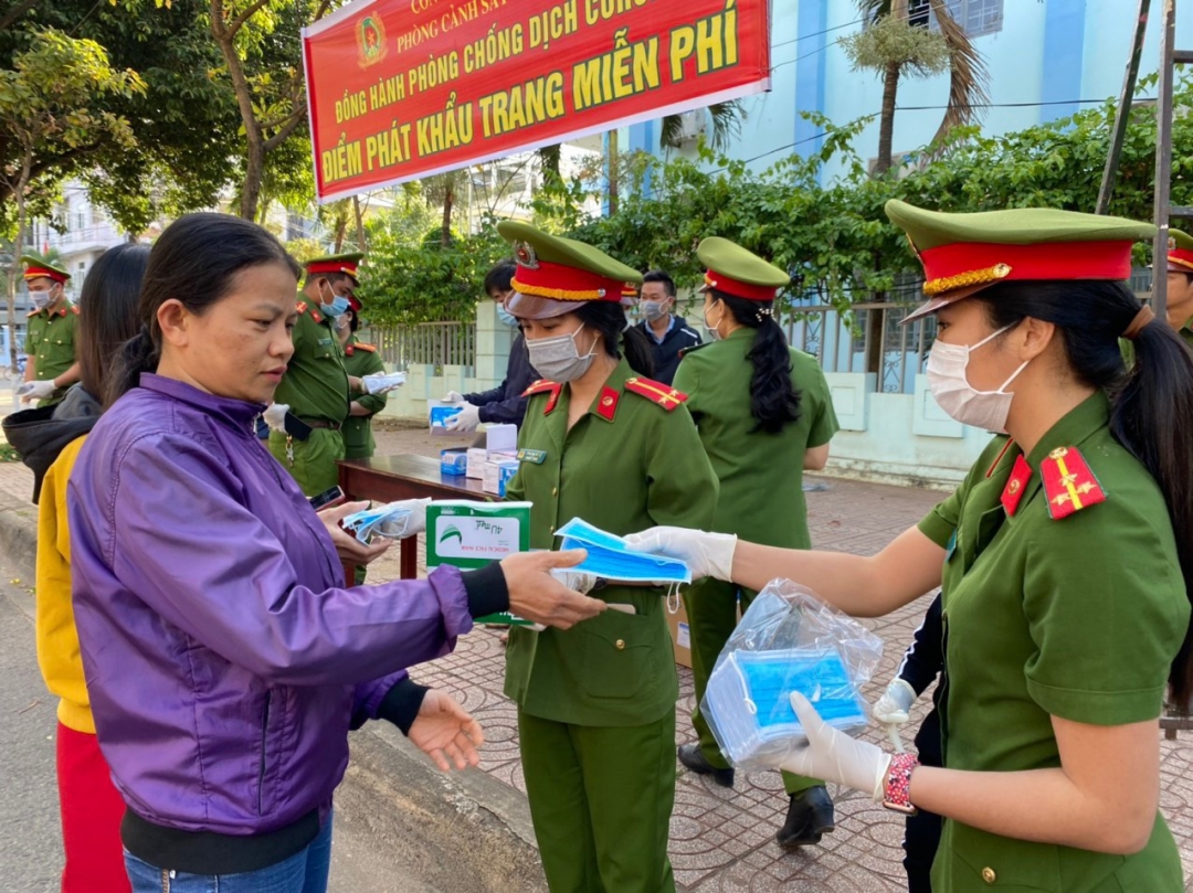Hội viên phụ nữ Công an tỉnh phát khẩu trang miễn phí cho người dân trên tuyến đường Nguyễn Tất Thành. 