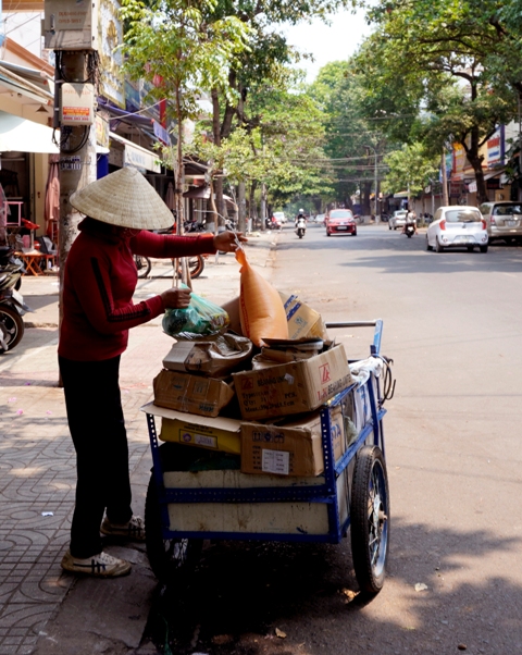 Chị H. làm nghề lượm ve chai phấn khởi vừa được nhận 10 kg gạo và mì tôm của quán chay Giác Đức