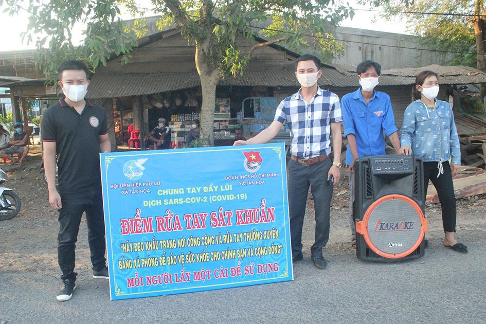 Anh Đào Xuân Hà (bìa trái) trong một buổi tuyên truyền, cấp phát khẩu trang phòng chống dịch Covid-19 trên địa bàn huyện Buôn Đôn. 
