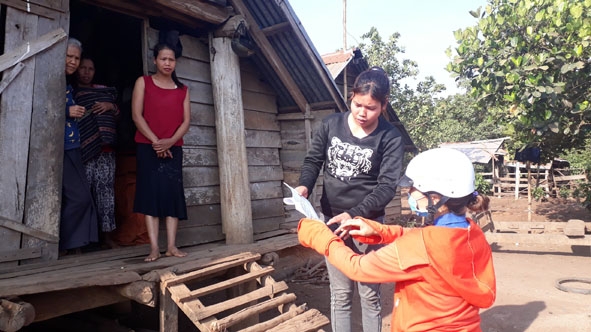 Cô Vũ Thị Nhung (bìa phải), giáo viên Trường Tiểu học Bùi Thị Xuân, xã Ea M'droh (huyện Cư M'gar) đến nhà học sinh hướng dẫn phụ huynh kèm con làm bài tập.   Ảnh: Lê Hương