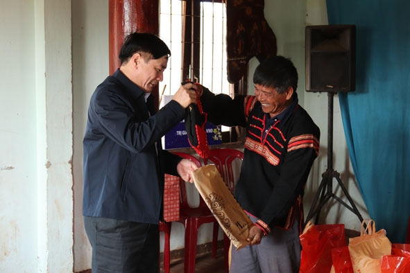 Người dân buôn căn cứ cách mạng Ea M’droh (xã Ea M’droh, huyện Cư M’gar) tặng áo thổ cẩm của người Êđê cho Bí thư Tỉnh ủy Bùi Văn Cường. 