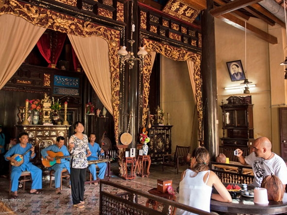 Du khách thưởng thức đờn ca tài tử ở nhà cổ Cai Cường. 