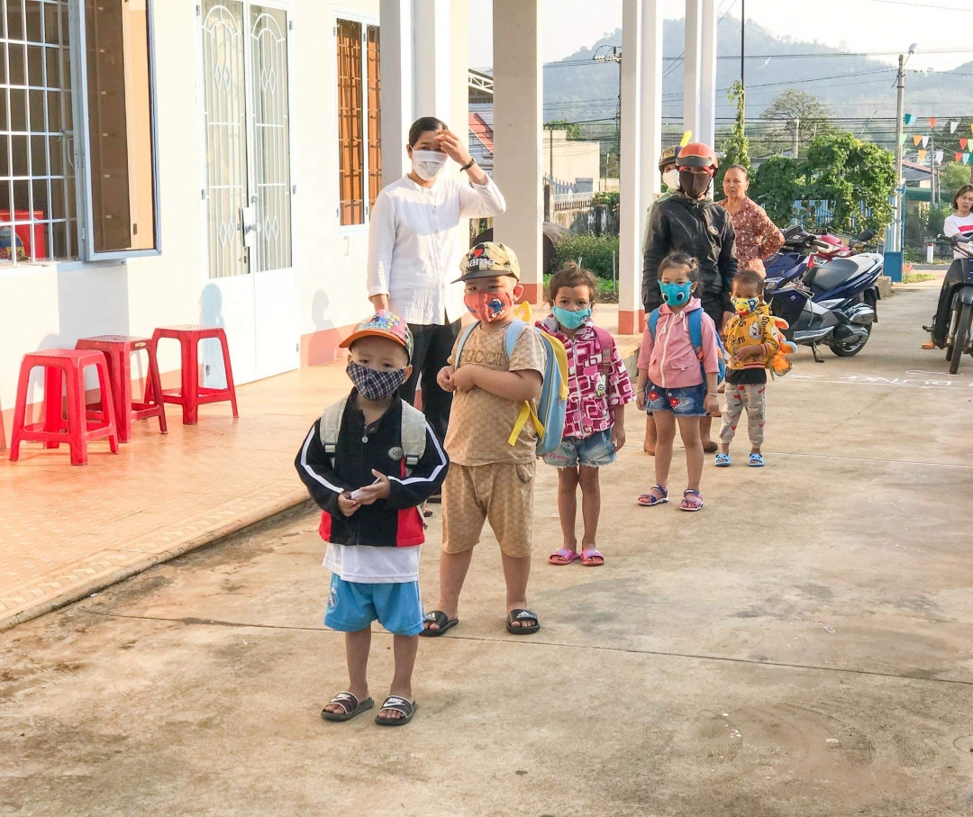 Học sinh Trường Mầm non Tư thục Vinh Sơn (xã Ea Nuôl, huyện Buôn Đôn) xếp hàng ngay ngắn đúng khoảng cách để đợi rửa tay sát khuẩn trước khi vào lớp. Ảnh: H.Ân