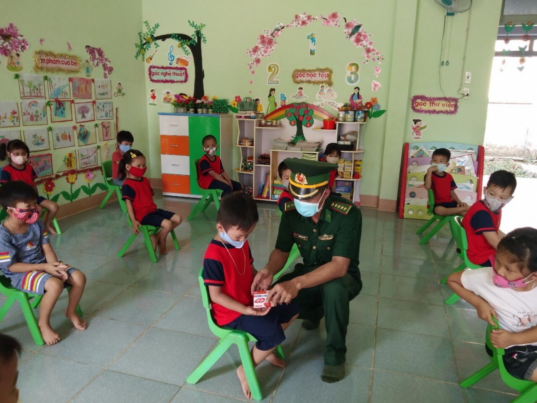 Cán bộ đội công tác địa bàn Đồn Biên phòng Cửa khẩu Đắk Ruê trao xà phòng cho các em học sinh tại trường Mần non Ea Bung