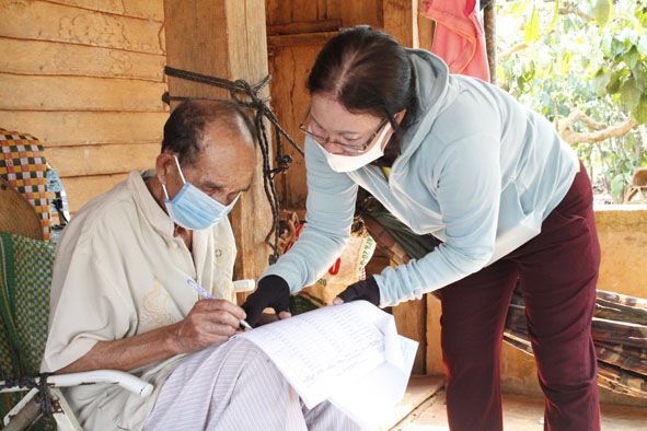 Ông Y Krắk M'lô (buôn Ea Tút, xã Pơng Drang, huyện Krông Búk) được nhân viên bưu điện chi trả lương hưu tại nhà. 