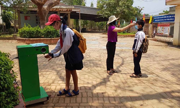 Học sinh Trường THCS Lương Thế Vinh lấy dụng dịch sát khuẩn từ chiếc máy rửa tay tự động.