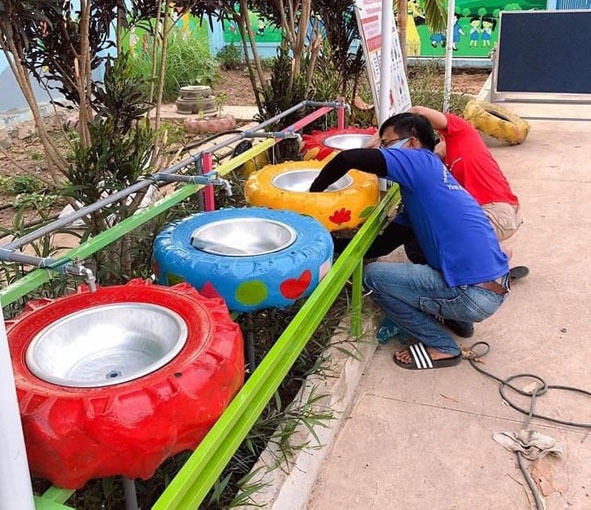 Đoàn viên thanh niên xã Ea Wer (huyện Buôn Đôn) lắp đặt bồn rửa tay từ lốp xe  tại Trường Mầm non Hoa Anh Đào.