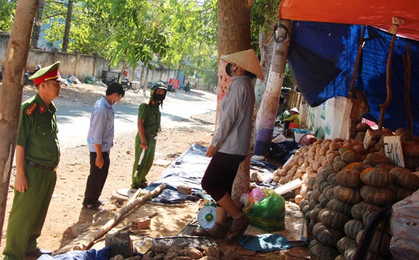 Công an phường Ea Tam tuyên truyền người dân không lấn chiếm hành lang an toàn giao thông để buôn bán. 
