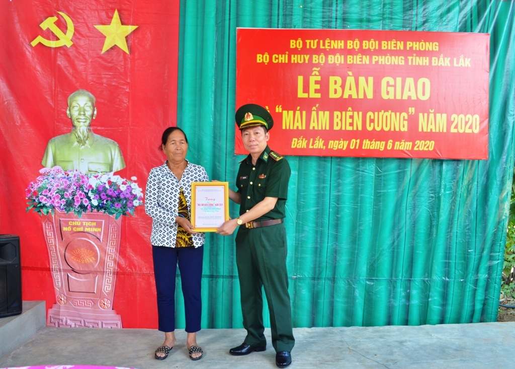 Đại tá Đỗ Quang Thấm, Phó Chính ủy Bộ đội Biên phòng tỉnh trao quyết định tặng nhà cho bà Đoàn Thị Hồng