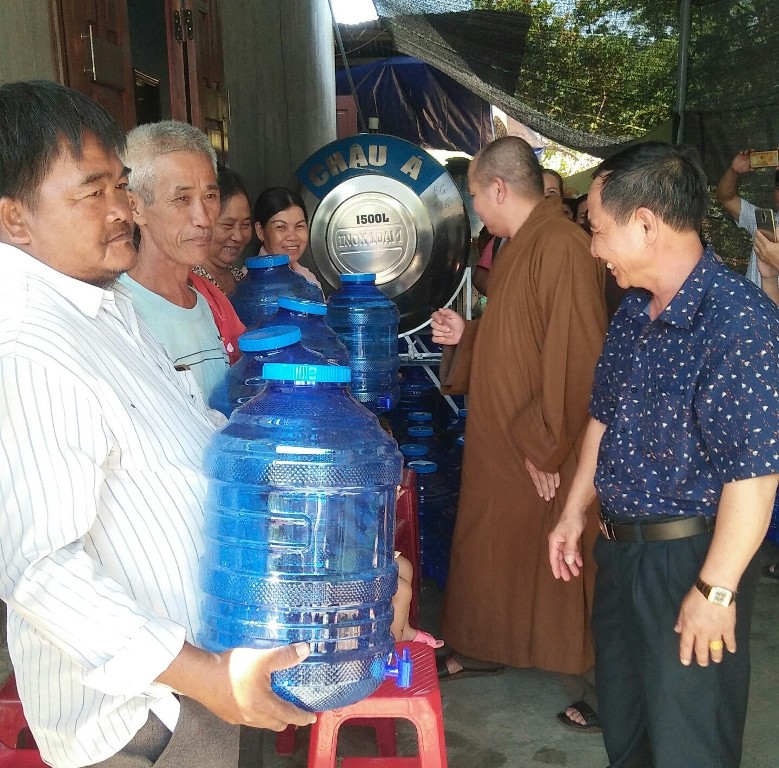 Đại diện các đơn vị trao bình nước tặng bà con