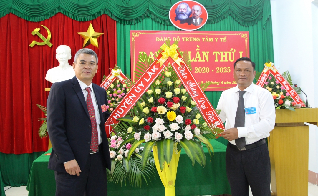 Phó Bí thư Huyện ủy Lắk Nay Y Phú (bên phải) tặng lẵng hoa chúc mừng đại hội. 