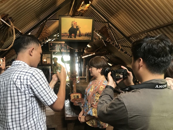 Phóng viên, nhà báo đang ghi hình bằng điện thoại thông minh tại nhà cố Nghệ sĩ Nhân dân Y Moan. 