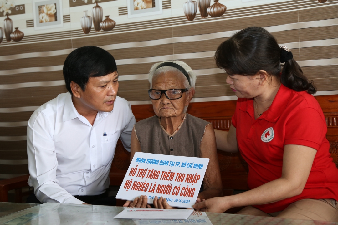 Đại diện Sở Lao động - Thương binh - Xã hội, Hội Chữ thập đỏ tỉnh trao bảng tượng trưng hỗ trợ thu nhập cho bà Đỗ Thị Hồng Châu - cựu tù chính trị.