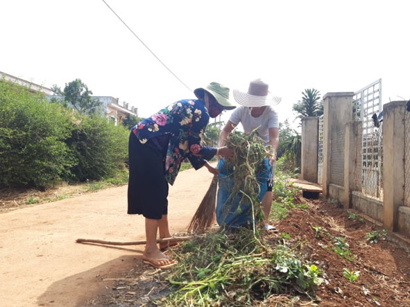 Người dân buôn Lắk B (xã Ea Drông, TX. Buôn Hồ) dọn vệ sinh môi trường.