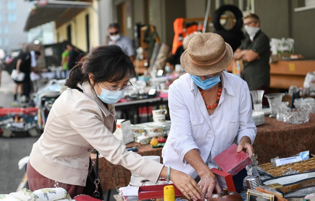 Người dân đeo khẩu trang phòng lây nhiễm Covid-19 tại một khu chợ ở Frankfurt, Đức. Ảnh: THX/TTXVN