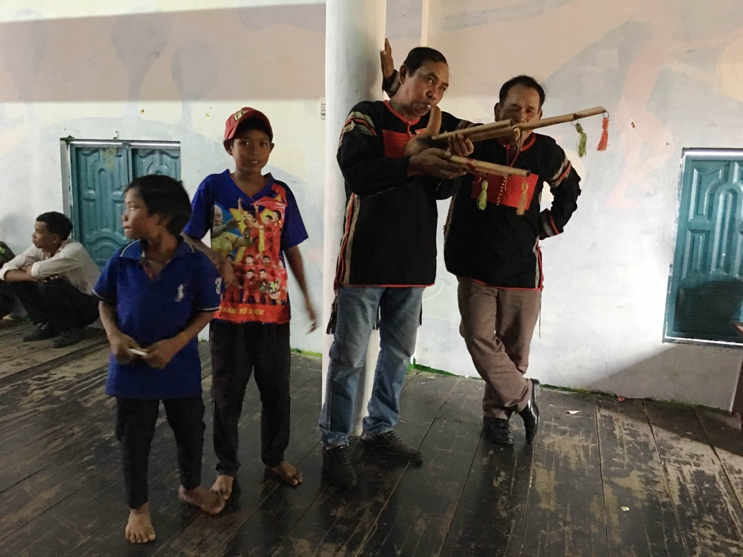Ama Phin (thứ hai từ phải sang) giao lưu nhạc cụ với nghệ nhân tại buôn M'um, xã Krông Jing.
