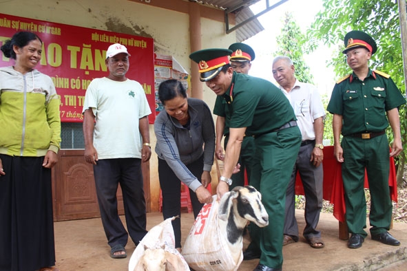 Đại diện Ban Chỉ huy Quân sự huyện Cư M’gar trao dê giống tặng các hộ gia đình.