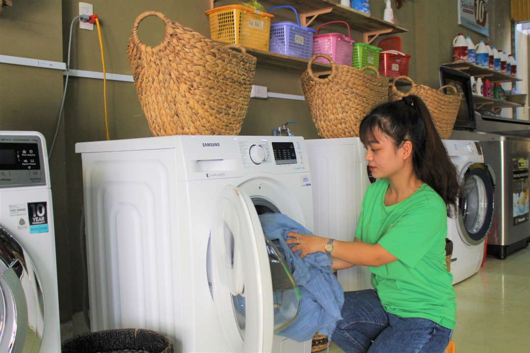 Nhân viên cửa tiệm giặt ủi Bà Ngoại đang giặt đồ cho khách hàng.