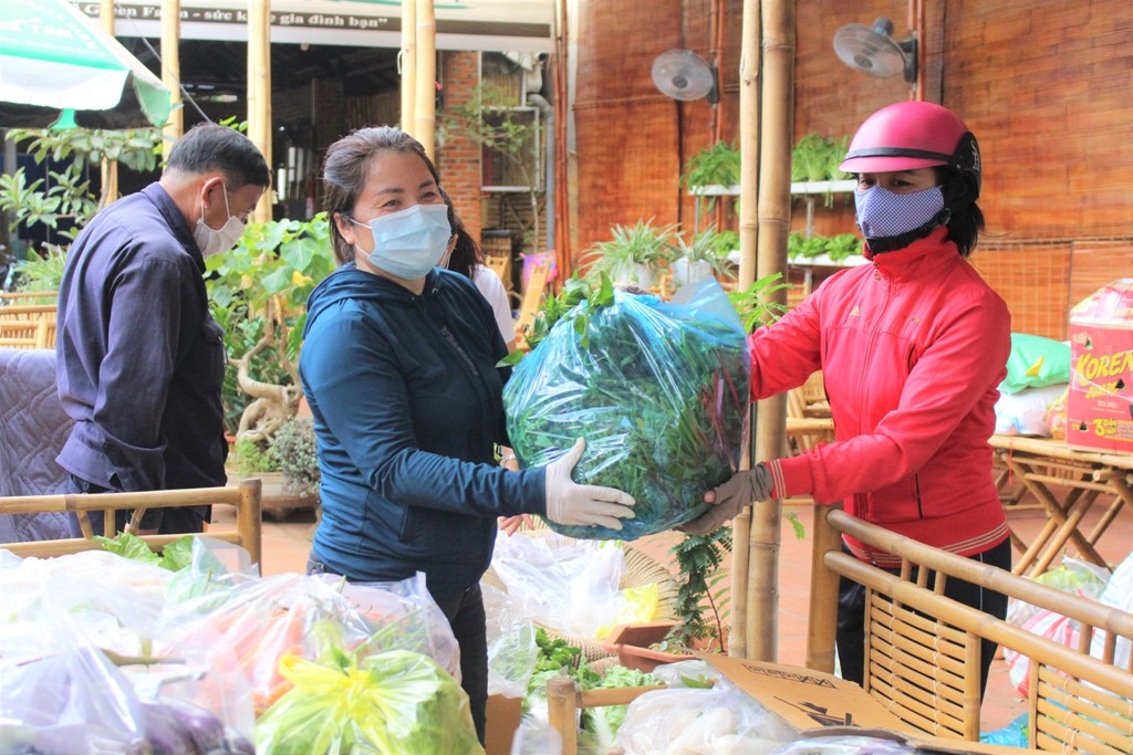 Chị Nguyễn Thị Thái Thanh (bên trái) nhận rau quyên góp từ người dân trên địa bàn tỉnh. 