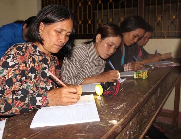 Các học viên lớp học xóa mù chữ ở buôn Drai (xã Ea Na, huyện Krông Ana) miệt mài tập viết chữ tại lớp học. 