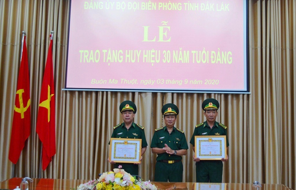 Đại tá Phạm Hữu Chiến, Bí thư Đảng ủy, Chính ủy Bộ đội Biên phòng tỉnh trao Huy hiệu cho các đảng viên