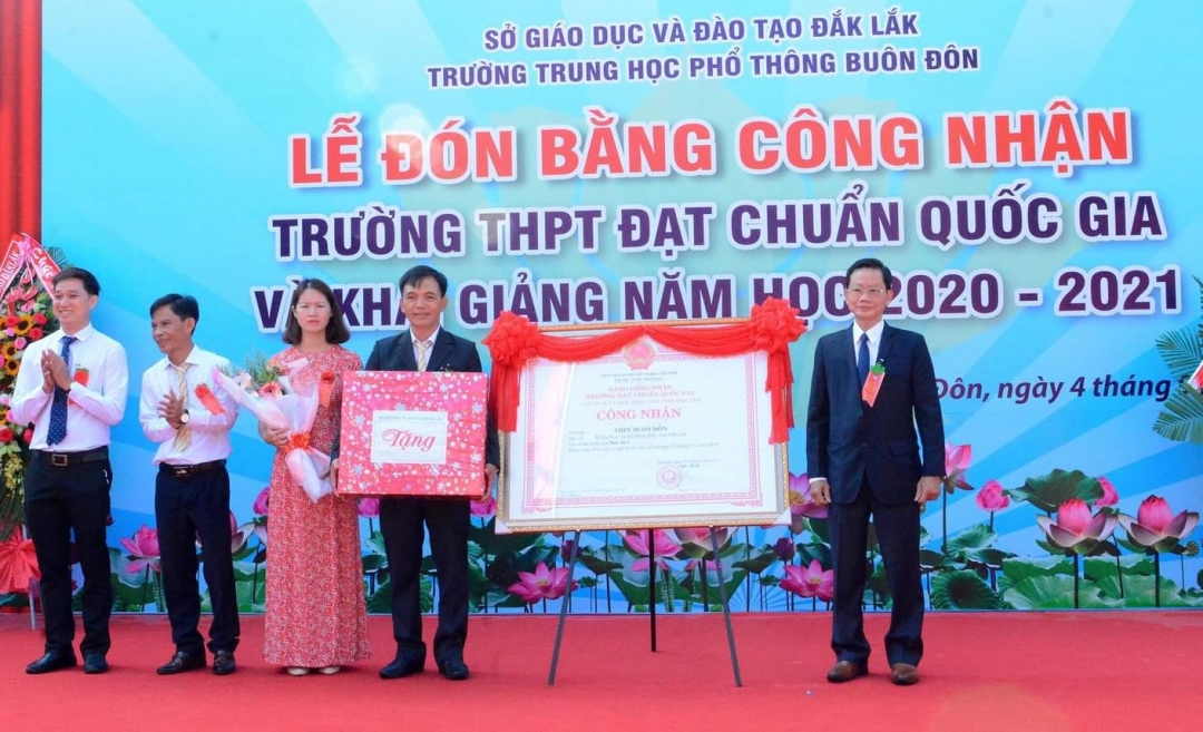 Thừa ủy quyền của UBND tỉnh, Phó Giám đốc Sở GD-ĐT Bùi Hữu Thanh Cát (bên phải) trao Bằng công nhận đạt chuẩn Quốc gia cho nhà trường. 