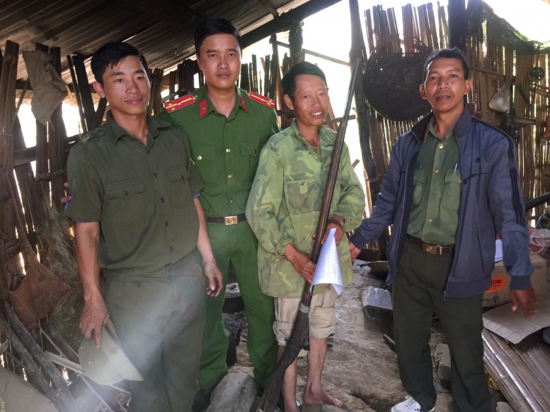 Anh Vàng Văn Páo (giữa) ở xã Hòa Phong (huyện Krông Bông) tự nguyện nộp lại vũ khí cho công an. (Ảnh: Công an huyện Krông Bông cung cấp)