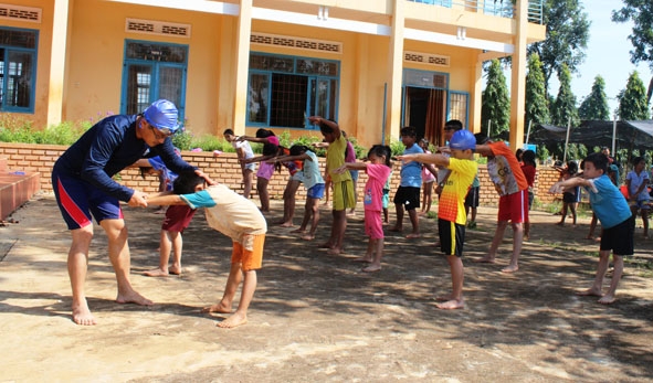 Các em học sinh thực hiện các bài tập bổ trợ trên cạn trước khi vào thực hành ở hồ bơi.