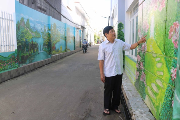Ông Đỗ Thái Cơ giới thiệu về con đường bích họa do người dân  tổ dân phố 1 đóng góp, xây dựng. 