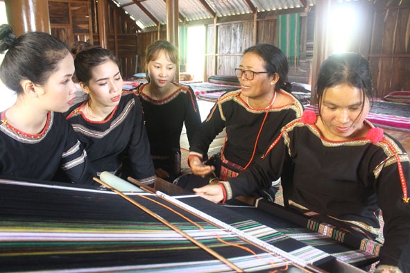 Bà H'Yam Bkrông, Giám đốc HTX Dệt thổ cẩm Tơng Bông (thứ hai từ phải sang) trao đổi, hướng dẫn xã viên kỹ thuật dệt thổ cẩm.