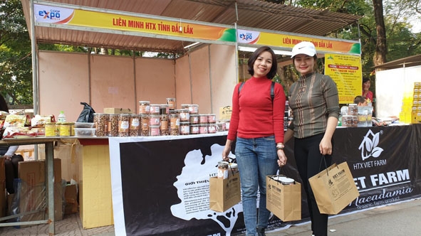 Du khách mua sản phẩm mắc ca của Hợp tác xã nông nghiệp Viet Farm tại Hội chợ xúc tiến thương mại, liên kết  các hợp tác xã do Liên minh Hợp tác xã Việt Nam tổ chức tại Hà Nội. 